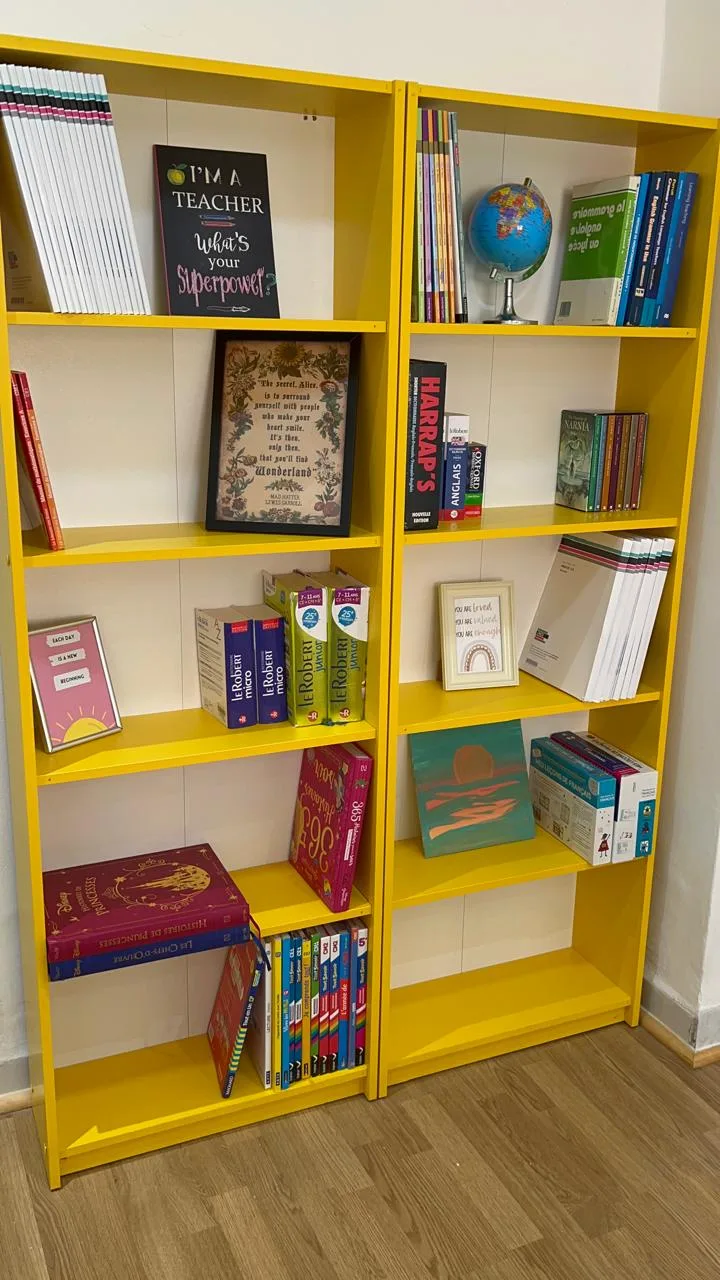 Bibliothèque jaune Wizaide remplie de livres, dictionnaires et ressources pédagogiques.