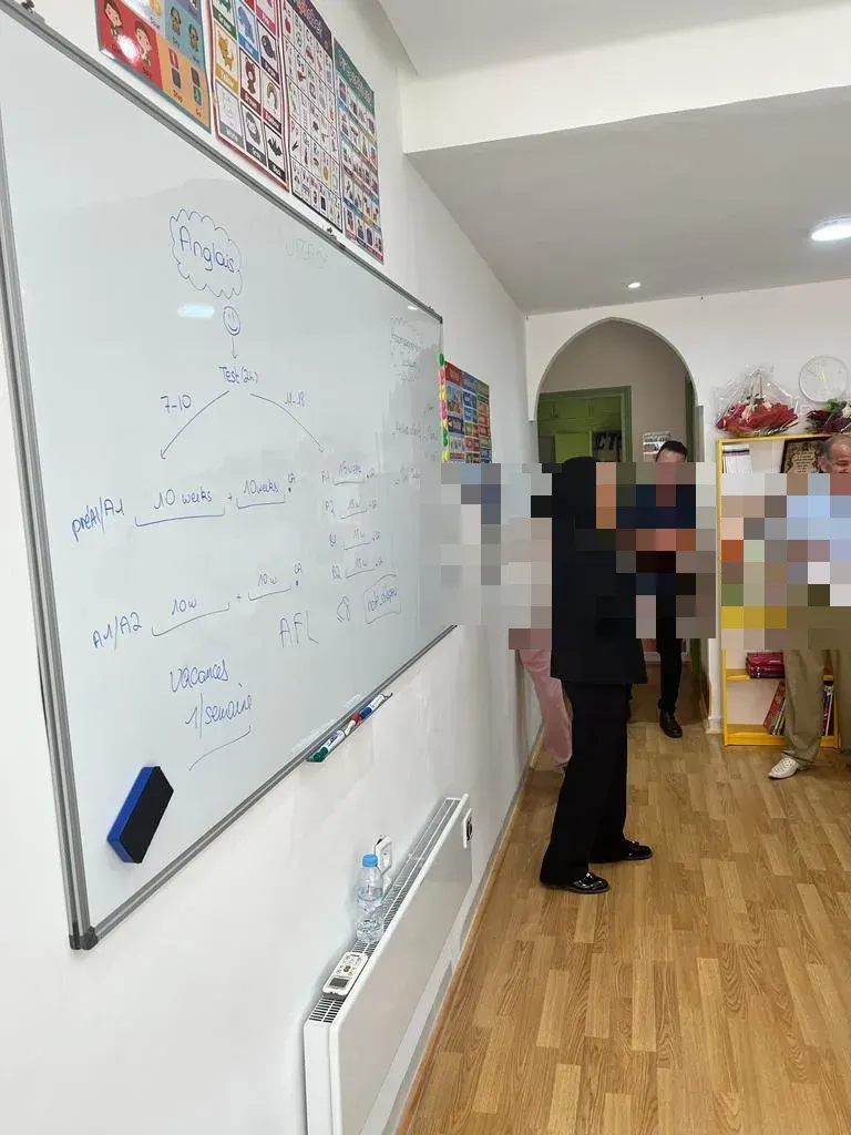 ماجدة الدغداگ، مؤسِّسة ويزايد، تشرح مسارًا تعليميًا للأولياء أمام السبورة.