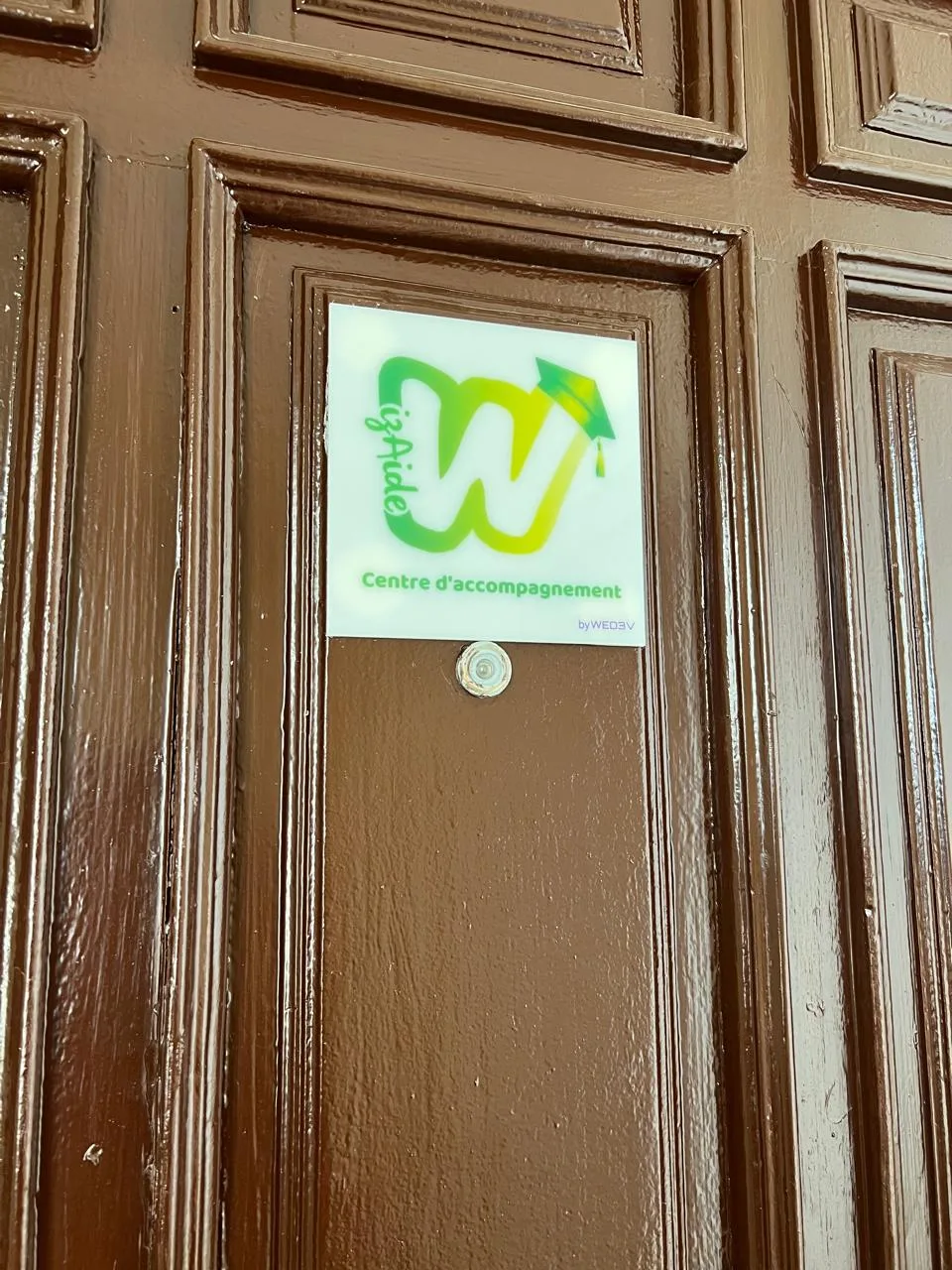 Entrée du centre Wizaide à Guéliz, Marrakech : porte en bois avec plaque "Centre d'accompagnement".