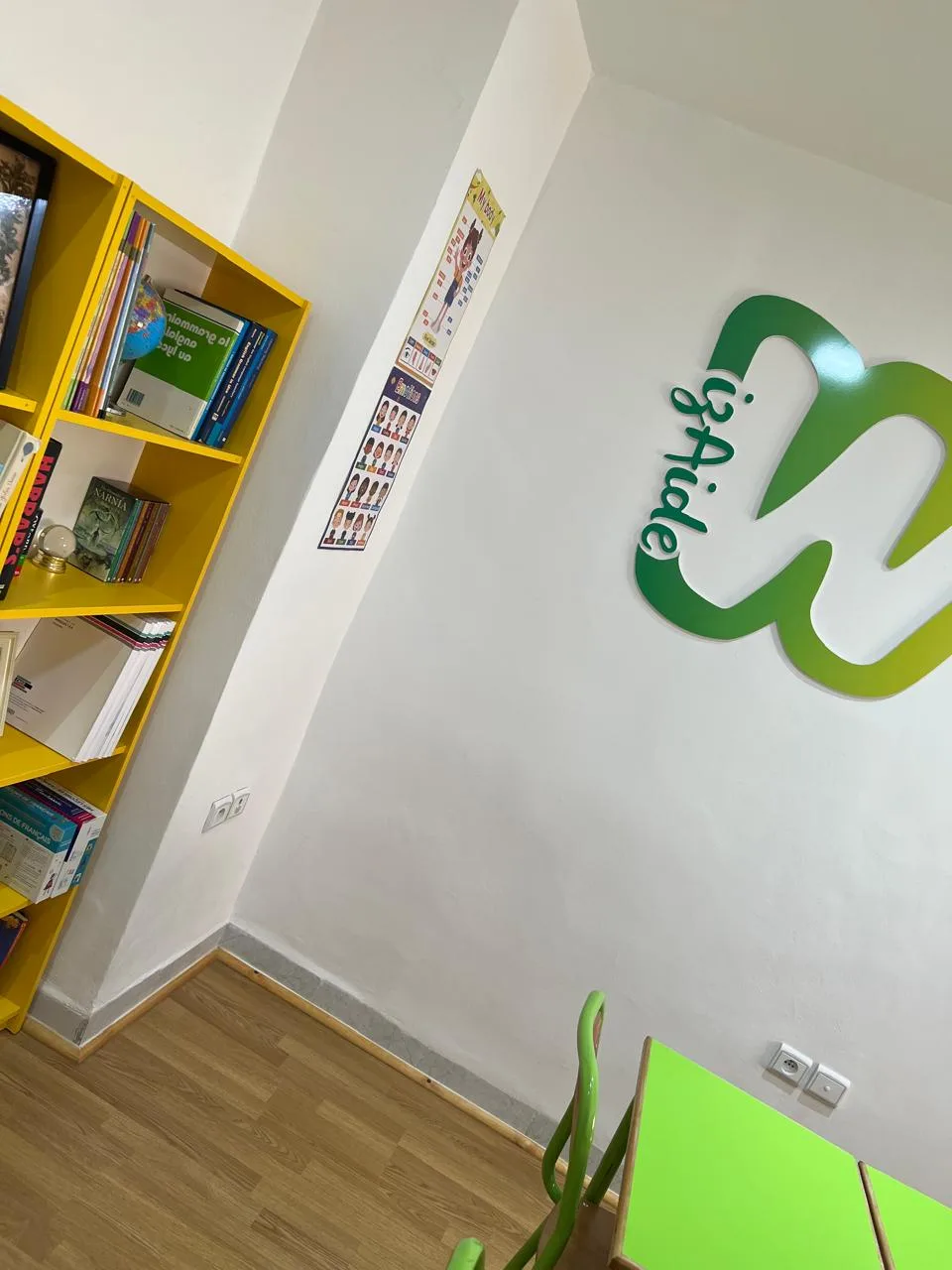 Logo Wizaide en relief vert et jaune sur le mur d'une salle de cours.
